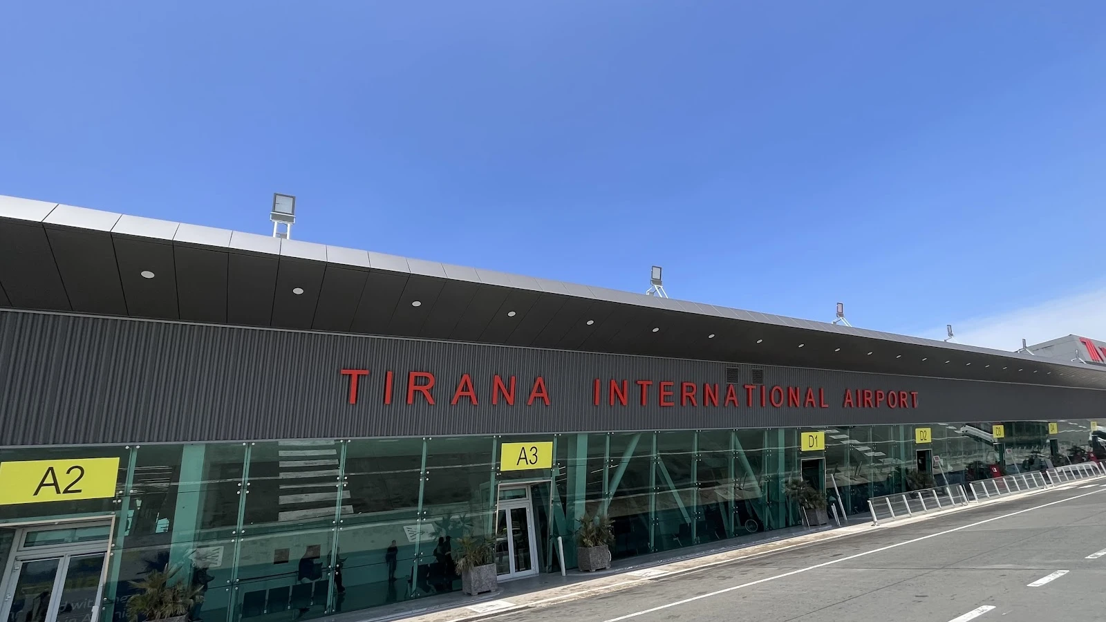 Tirana airport arrivals area with car rental pickup signs for travelers